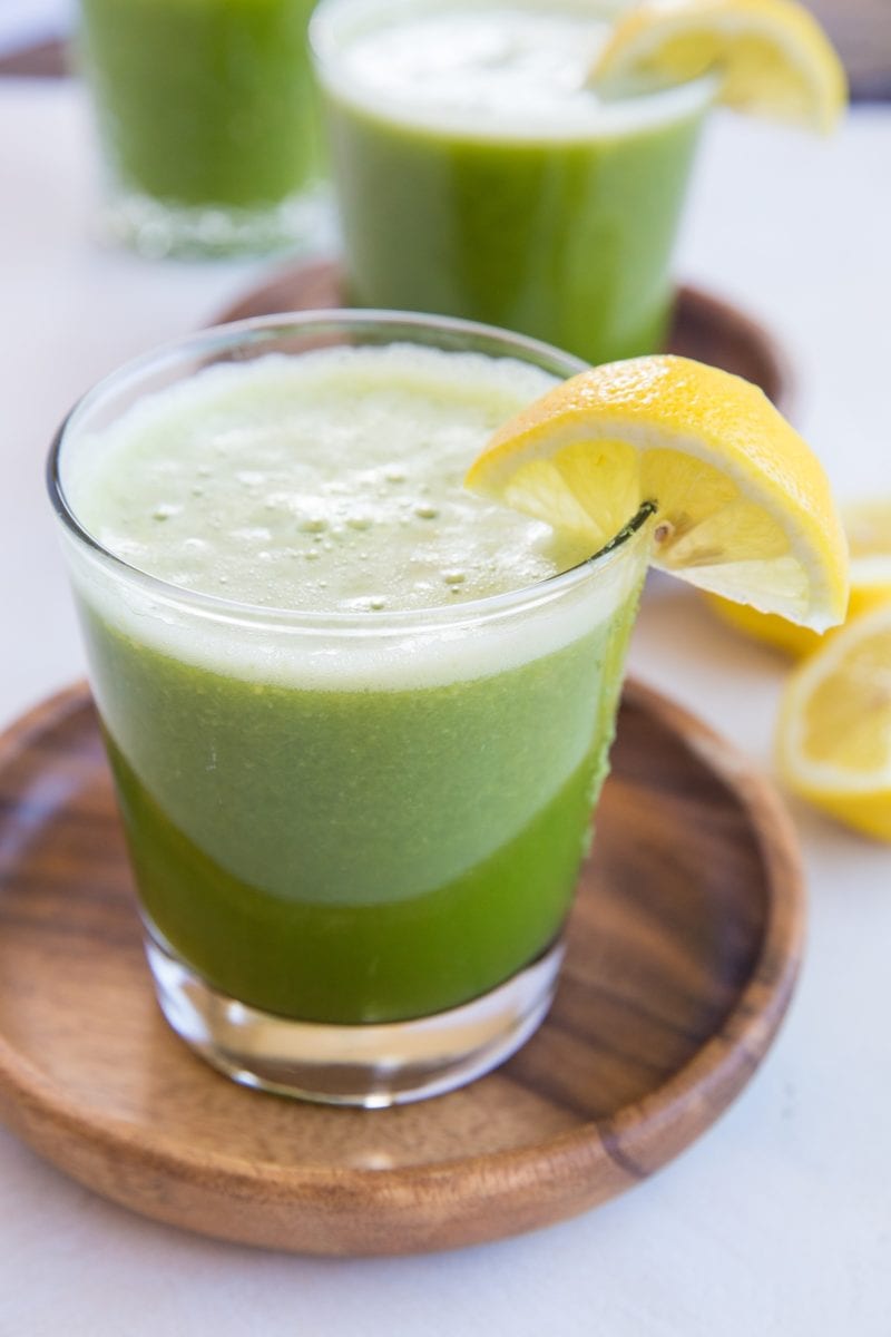 Two glasses of celery juice with slices of lemon.