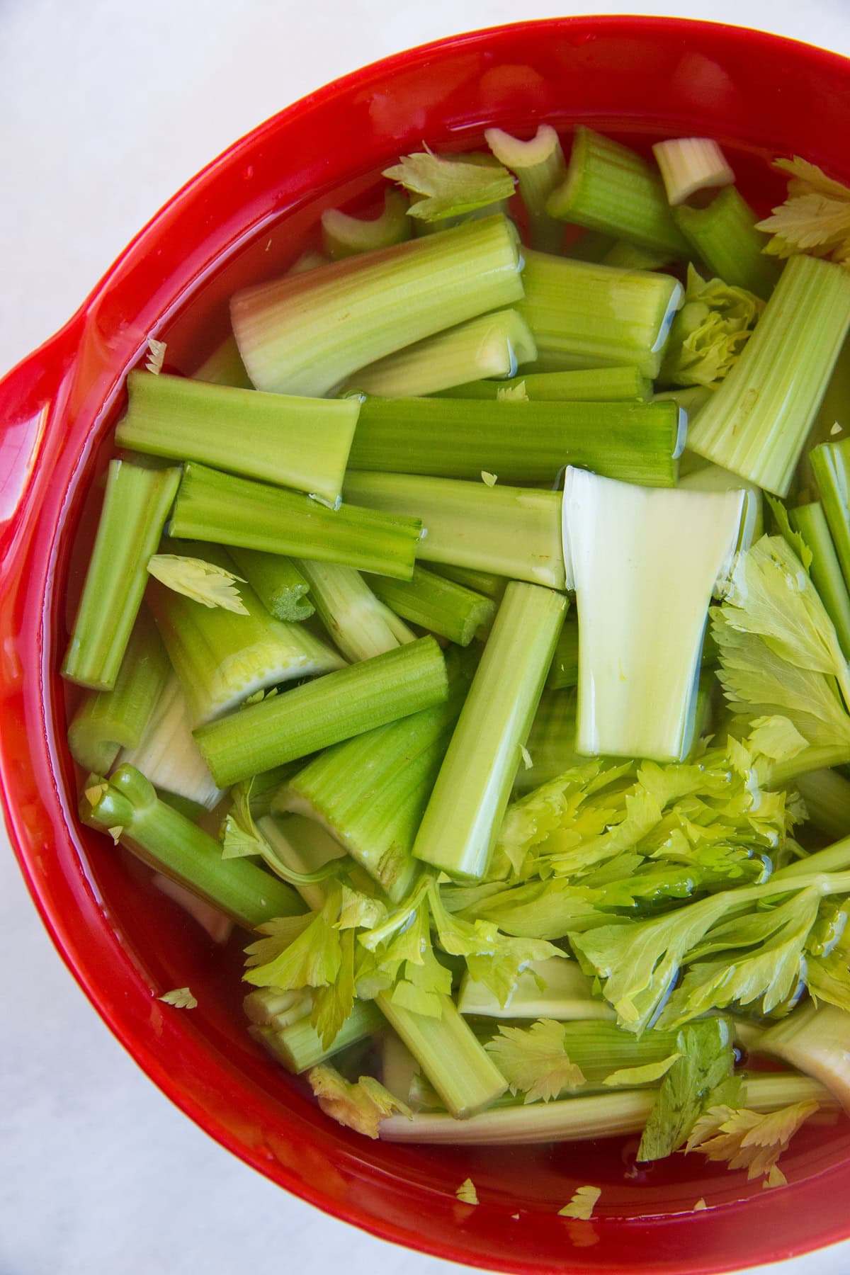 Celery soaking in apple cider vinegar and water in a mixing bowl.