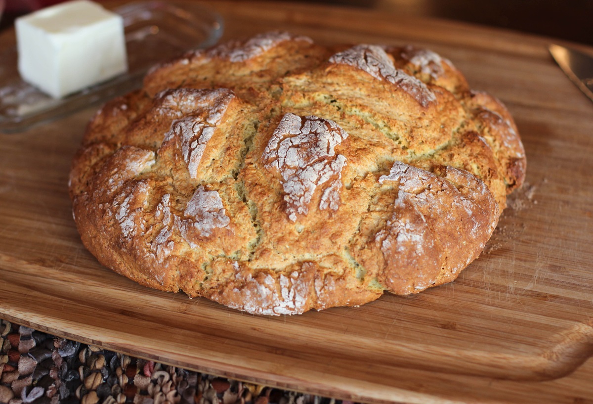 Full loaf of irish soda bread on a wooden cutting board, ready to serve.