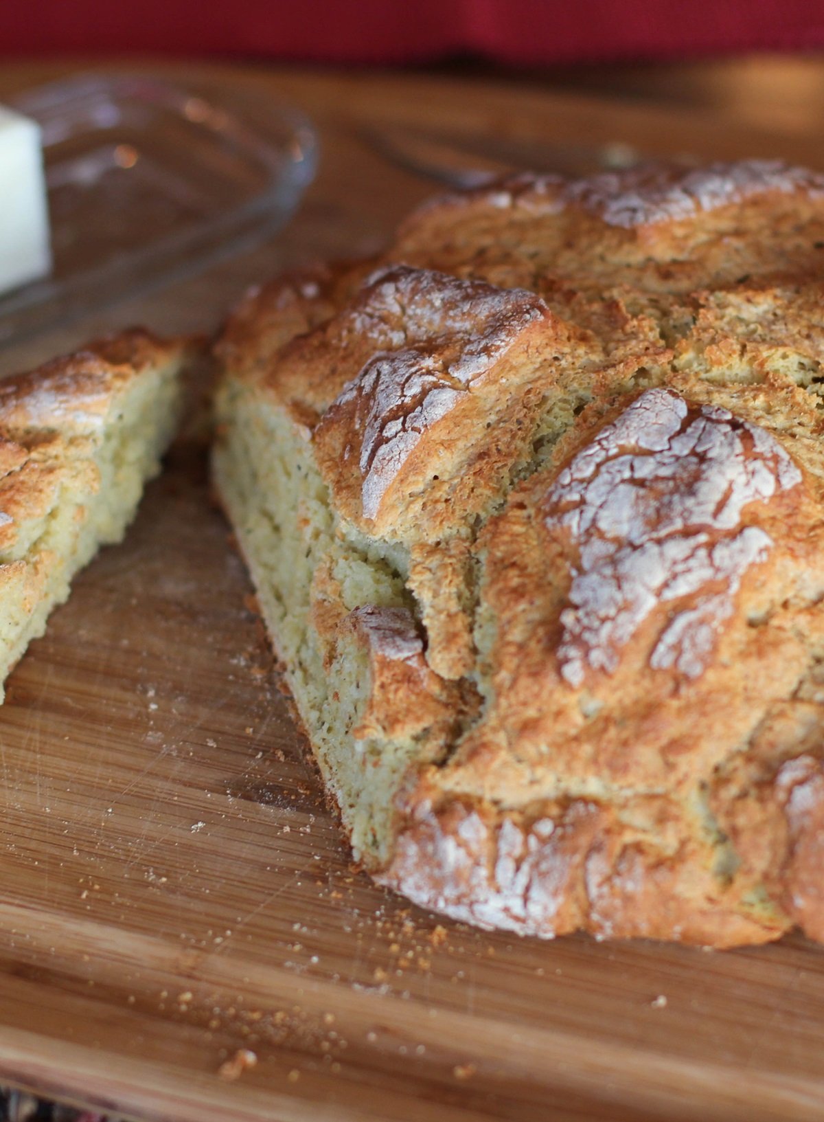 Loaf of bread on a cutting board with a slice cut out. Ready to eat.