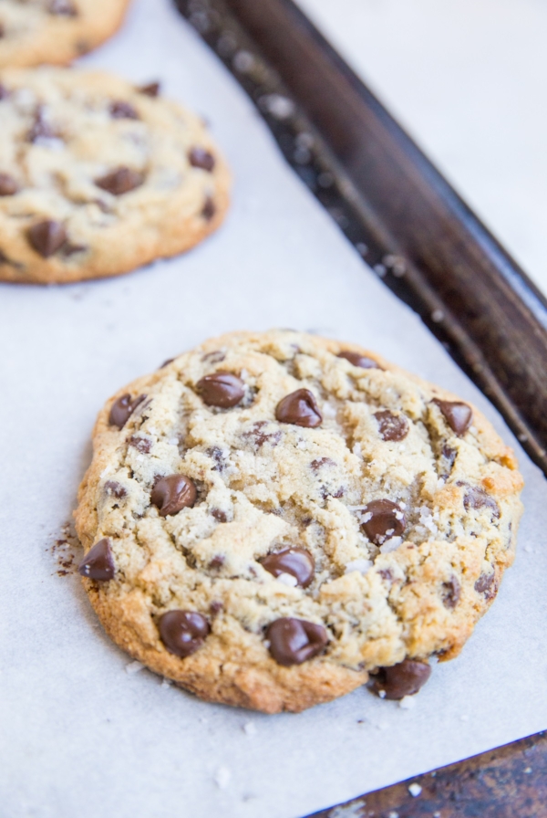 large low-carb chocolate chip cookies sitting on a baking sheet, ready to eat.