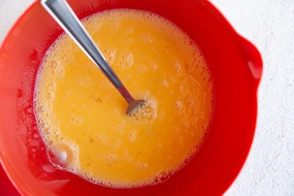 Beaten eggs in a mixing bowl.