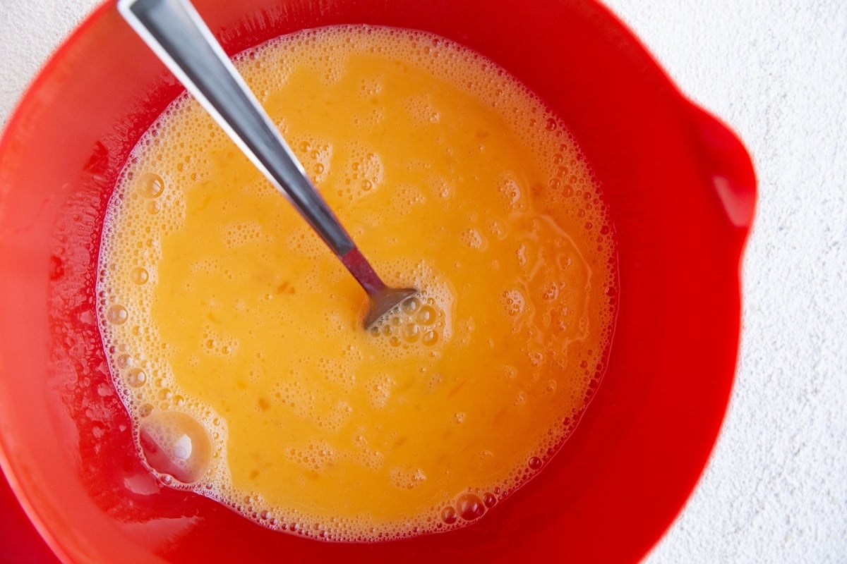 Beaten eggs in a mixing bowl.