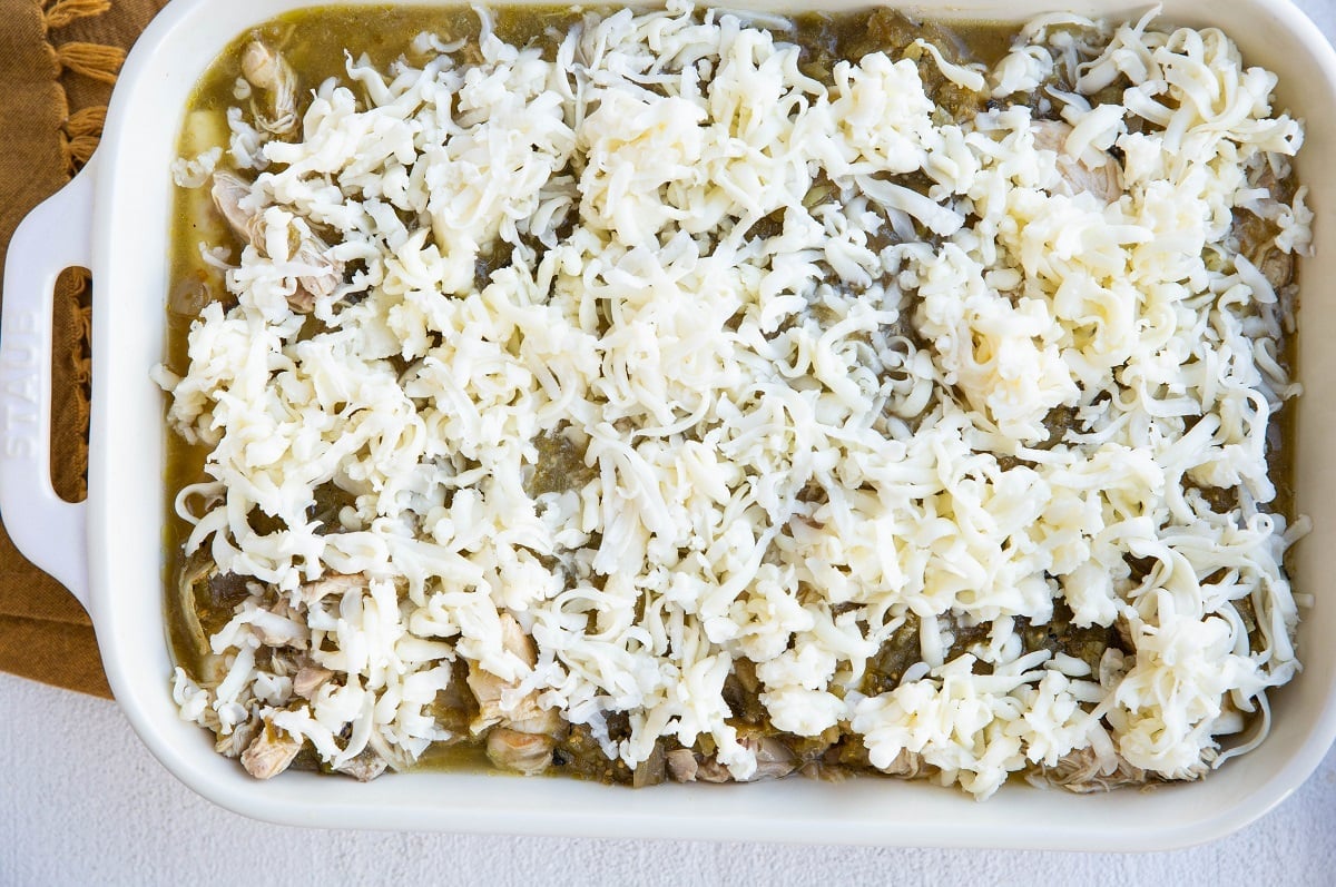 Enchiladas sprinkled with cheese, ready to bake.