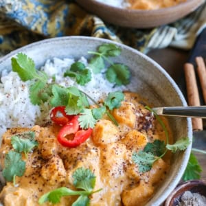 large ceramic bowl of chicken massaman curry with rice and cilantro.