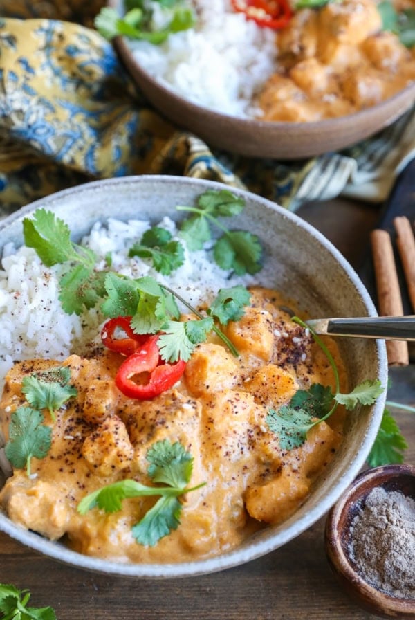 large ceramic bowl of chicken massaman curry with rice and cilantro.