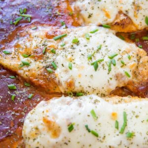 Cheesy baked chicken parmesan with mozzarella cheese and tomato sauce in a baking dish, fresh out of the oven.