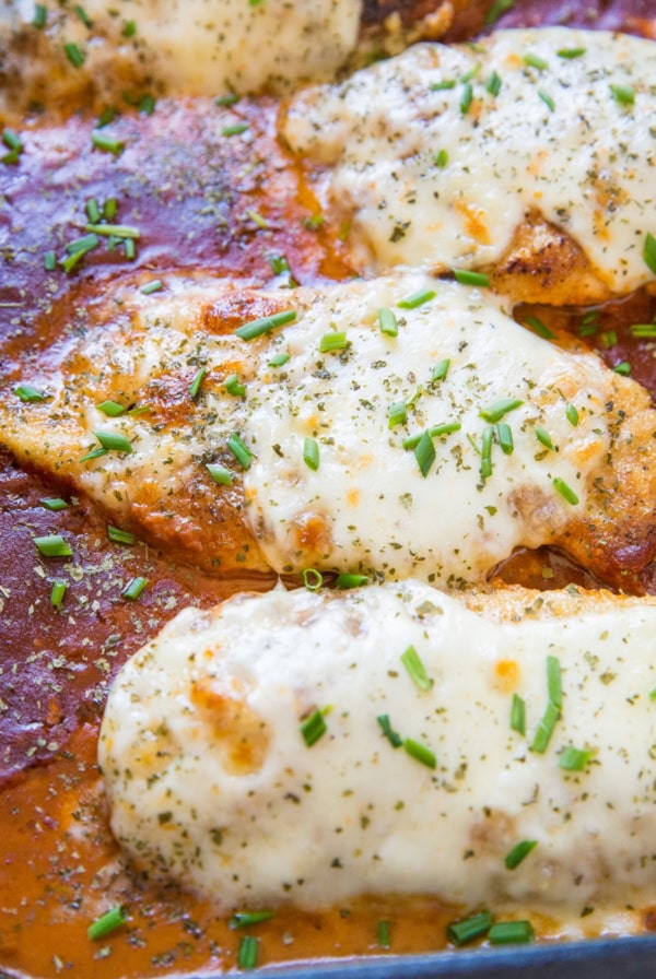 Cheesy baked chicken parmesan with mozzarella cheese and tomato sauce in a baking dish, fresh out of the oven.