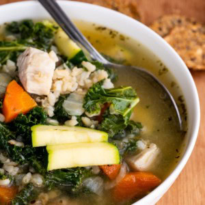 Big bowl of chicken soup with rice and kale