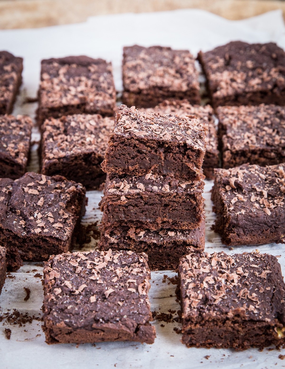Stack of chickpea brownies with more brownies to the sides.
