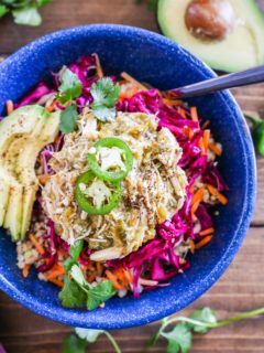 Blue bowl with rice, chile verde chicken, cabbage slaw, and avocado.