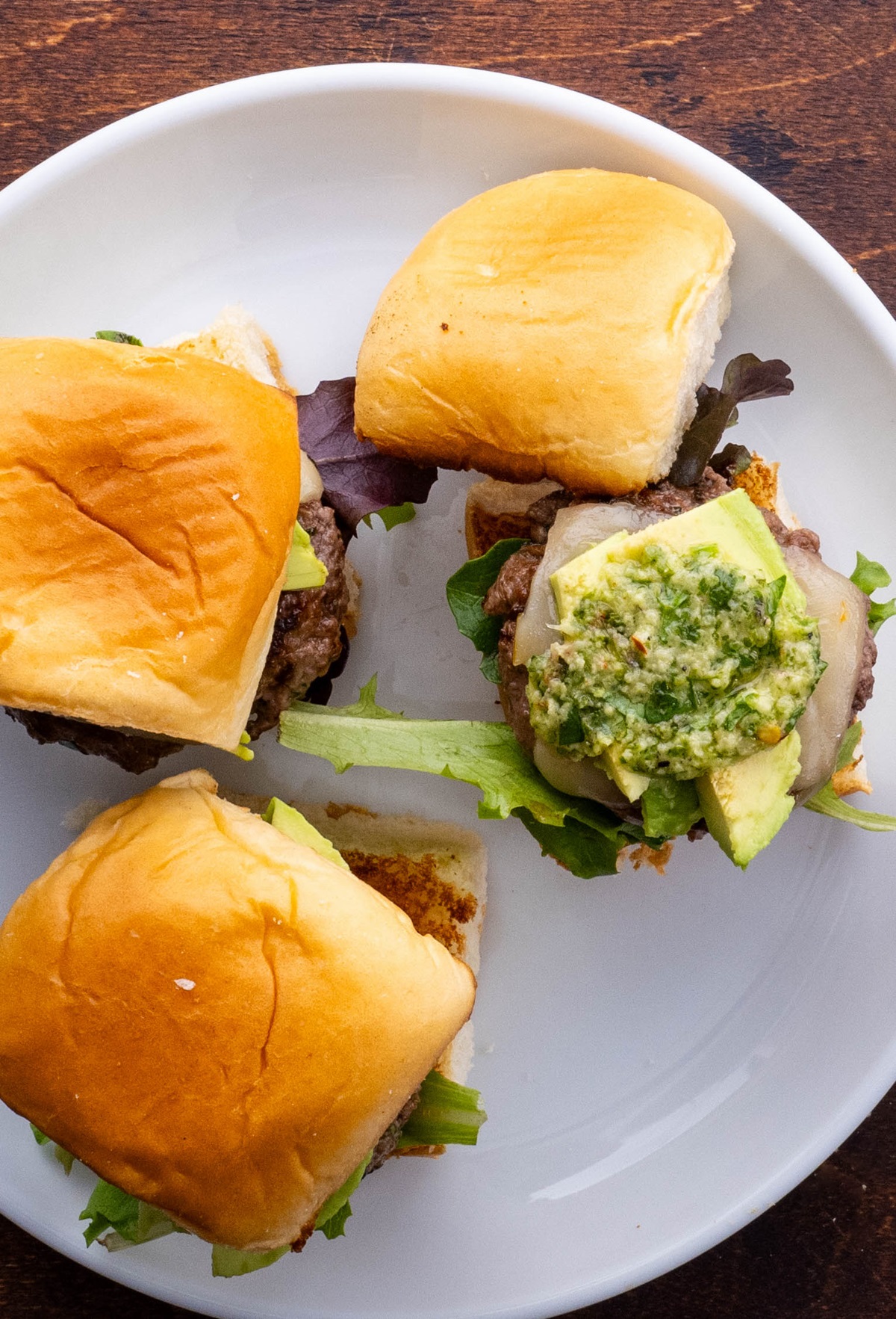 Three beef sliders on a plate, ready to eat.