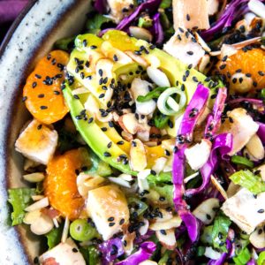 Healthy Chinese Chicken Salad in a large bowl, close up on the fresh vegetables and avocado. Ready to serve.