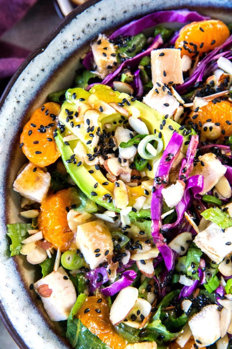 Healthy Chinese Chicken Salad in a large bowl, close up on the fresh vegetables and avocado. Ready to serve.