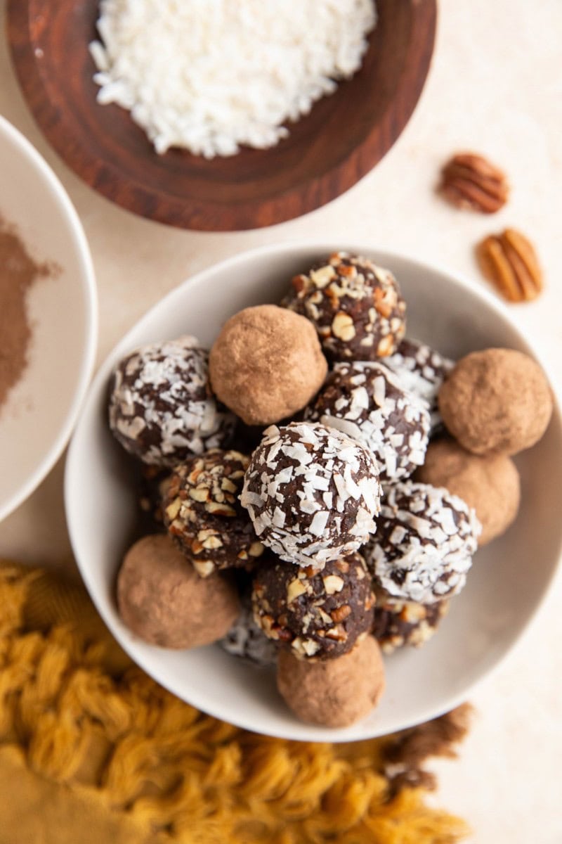 White bowl full of vegan chocolate truffles with a golden napkin to the side. Ready to eat!