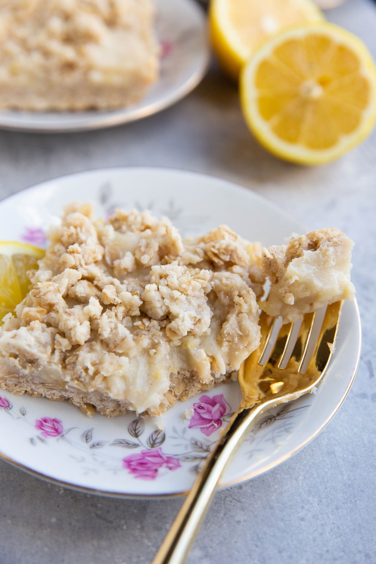 Lemon crumb bar on a tea saucer with a bite taken out.