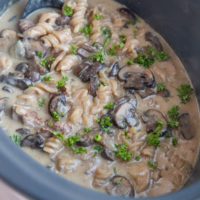 Crock pot full of creamy beef stroganoff, ready to serve.