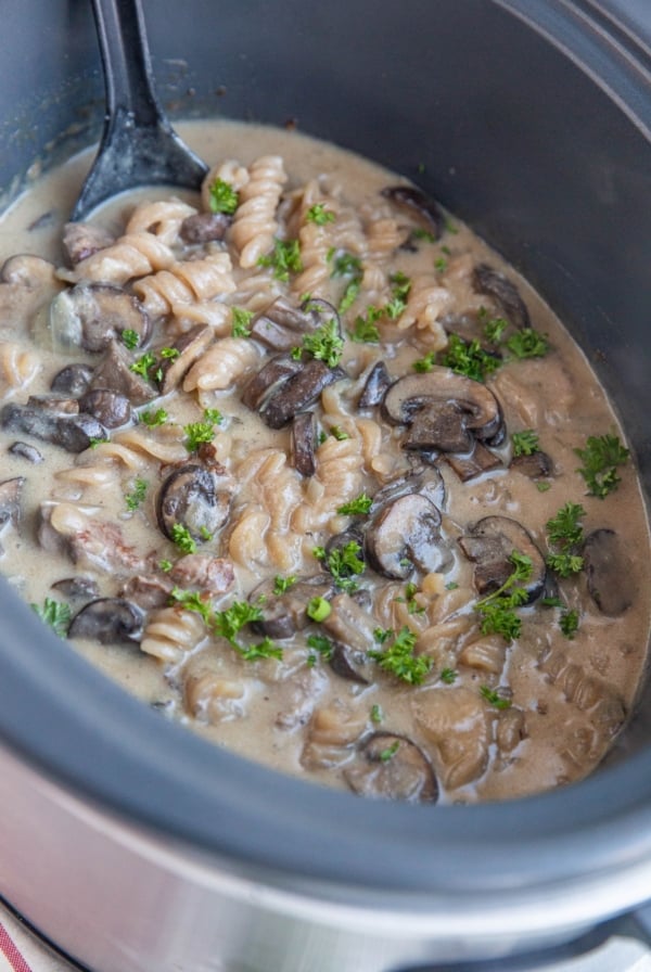 Crock pot full of creamy beef stroganoff, ready to serve.