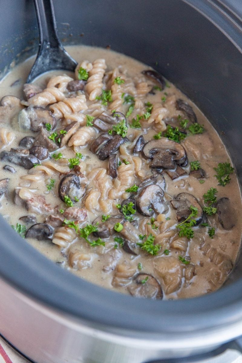 Crock pot full of creamy beef stroganoff, ready to serve.