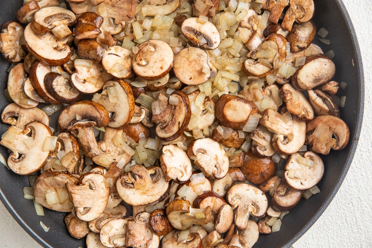 Onions, mushrooms and garlic sautéing in a skillet