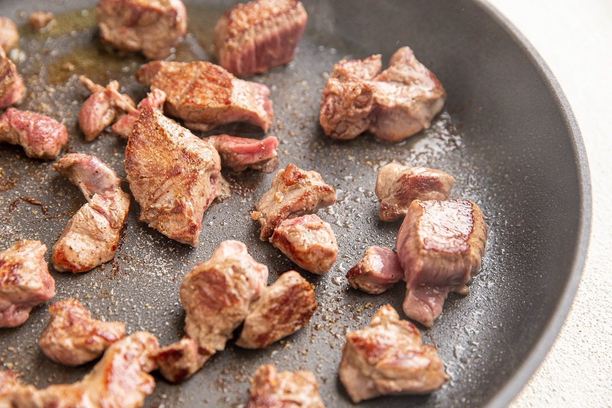 Beef cooking in a skillet to get a golden brown crust.