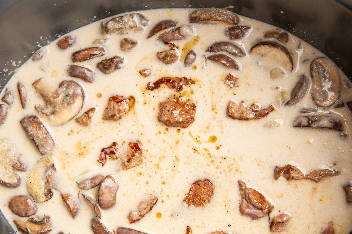 Beef and mushroom sauce in a slow cooker, ready to slow cook.