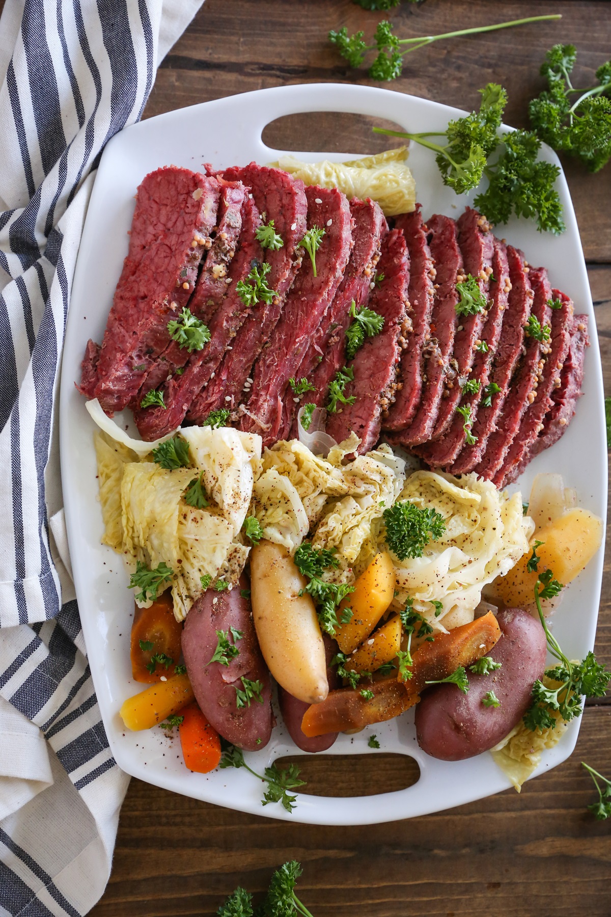 Platter of cooked corned beef, cabbage, potatoes, and carrots. Sliced up and ready to serve.