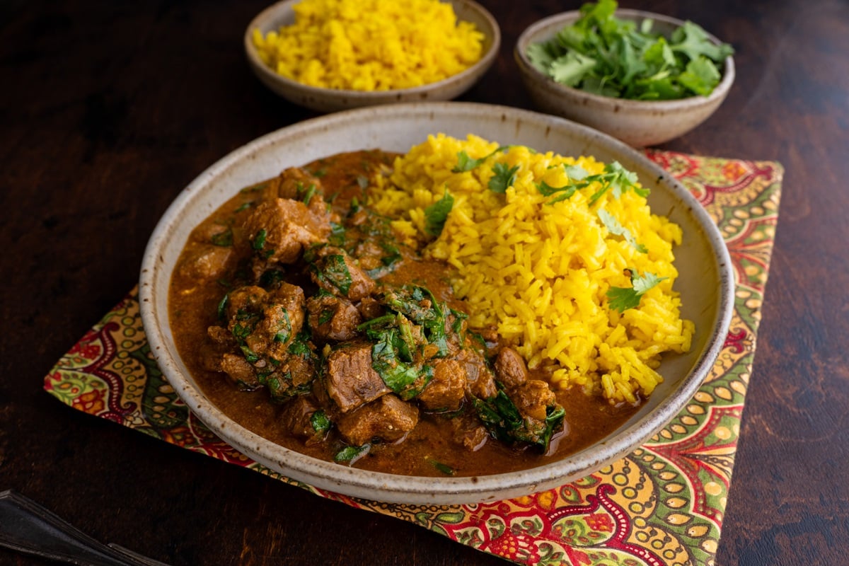 Big bowl of Indian curry with lamb and saffron rice.