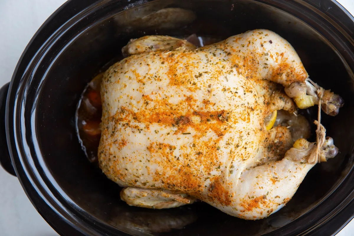 Finished whole chicken in a slow cooker, ready to serve.