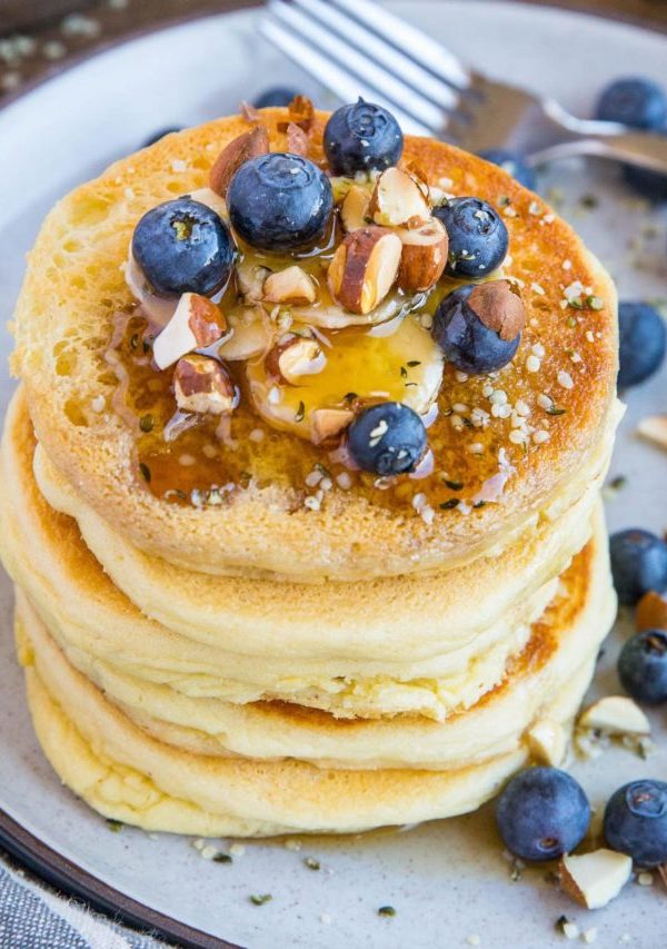 Almond flour pancakes on a plate with blueberries and banana, ready to eat
