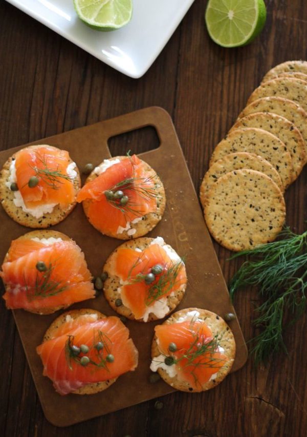 Cured salmon on crackers with fresh dill and capers, ready to serve.