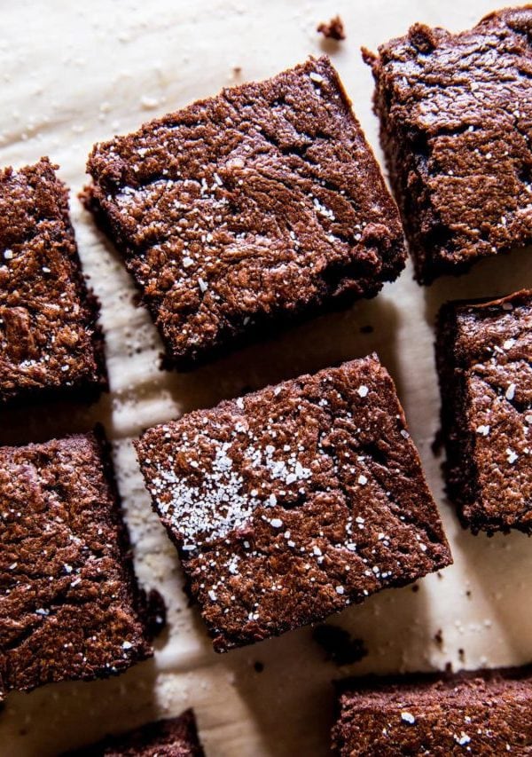 Keto brownies on a sheet of parchment paper, cut into individual slices.