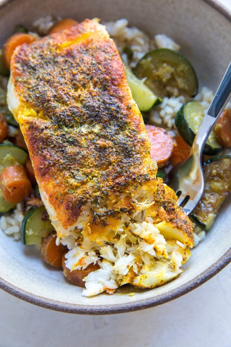 Low-fat Baked Cod with turmeric and paprika in a bowl with rice and veggies.