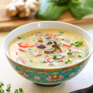 Large bowl of egg drop soup with chopped green onions and mushrooms on top.