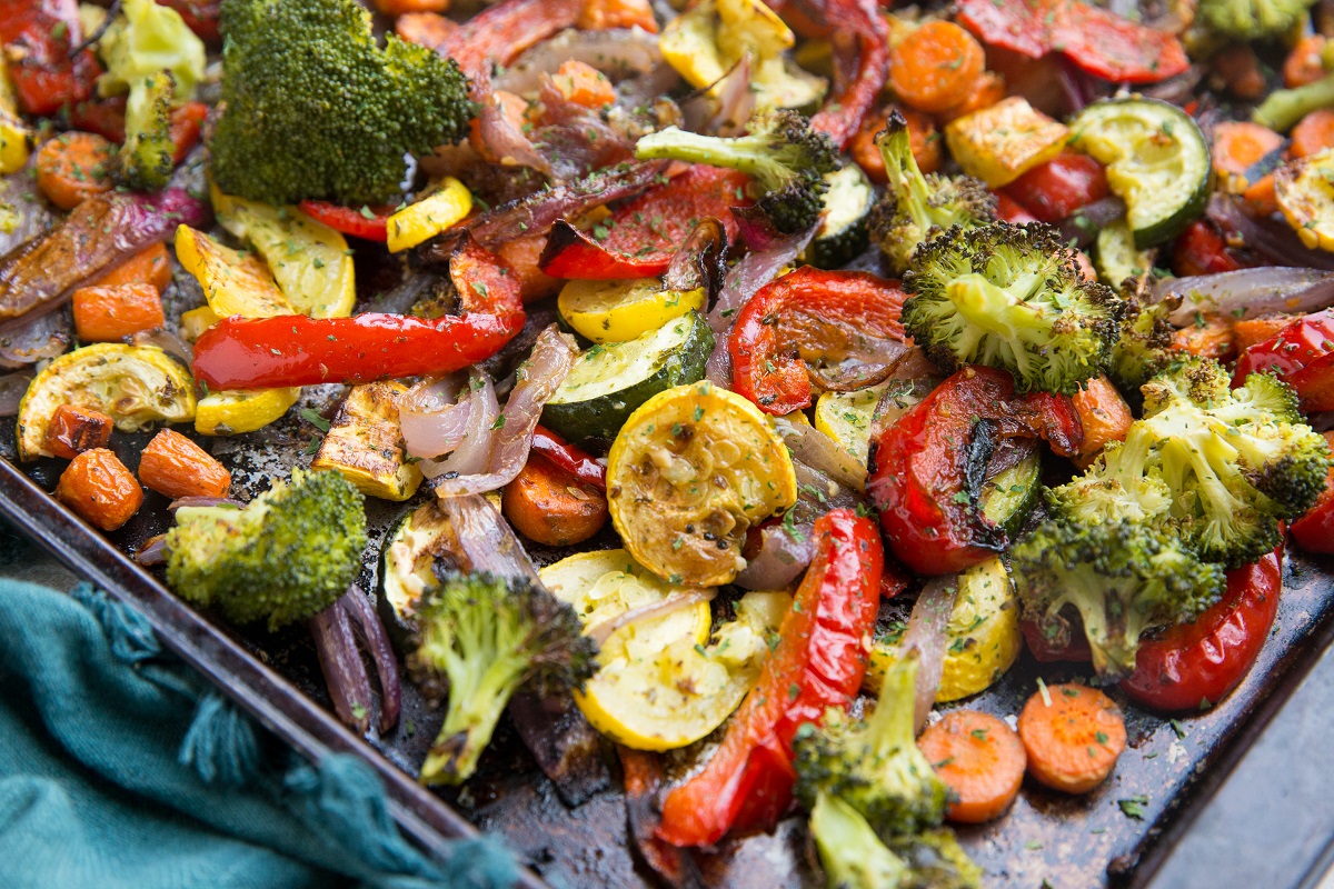 Garlic and Herb Roasted Vegetables on a sheet pan with a blue napkin, ready to serve.