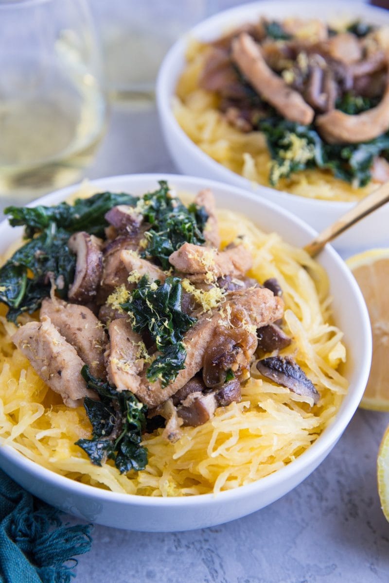 Chicken Garlic Spaghetti Squash with Kale and Mushrooms in two white bowls, ready to serve.