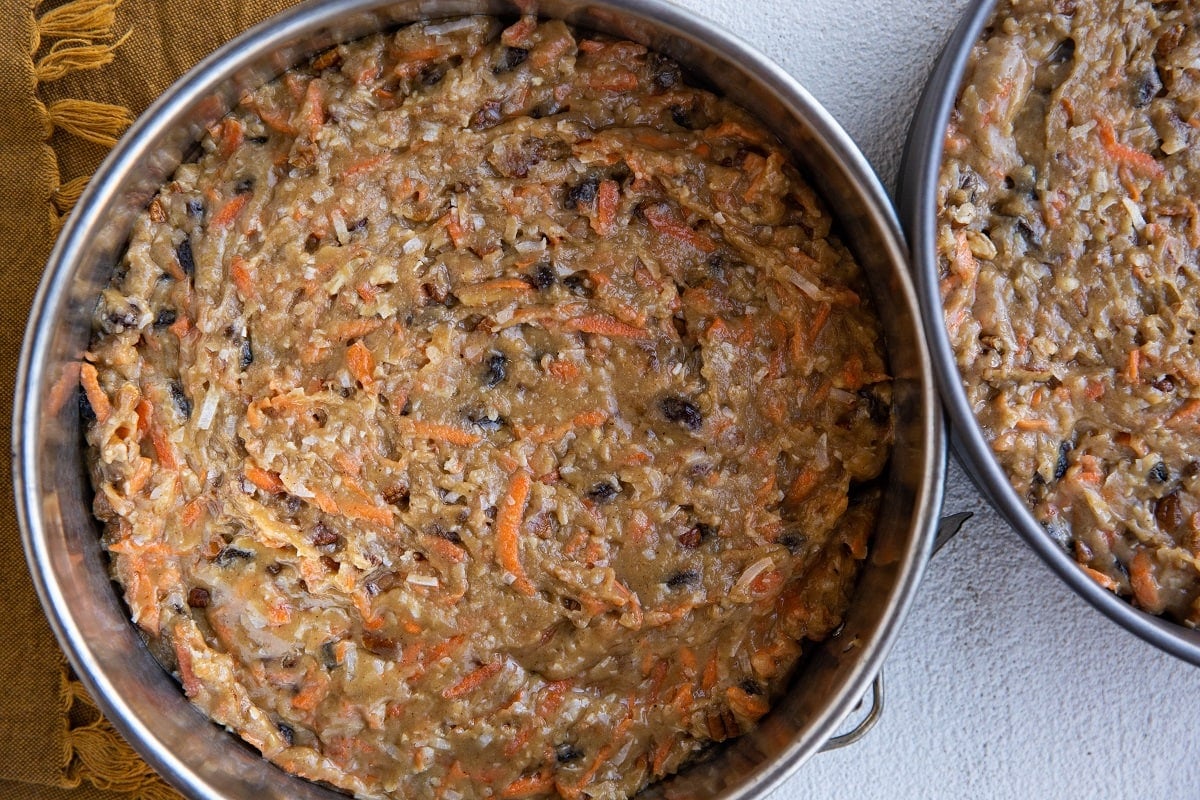 Two cake pans with carrot cake batter, ready to go into the oven.