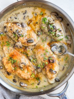 Stainless steel skillet with gluten-free dairy-free Chicken Marsala. A napkin to the side. Ready to serve.