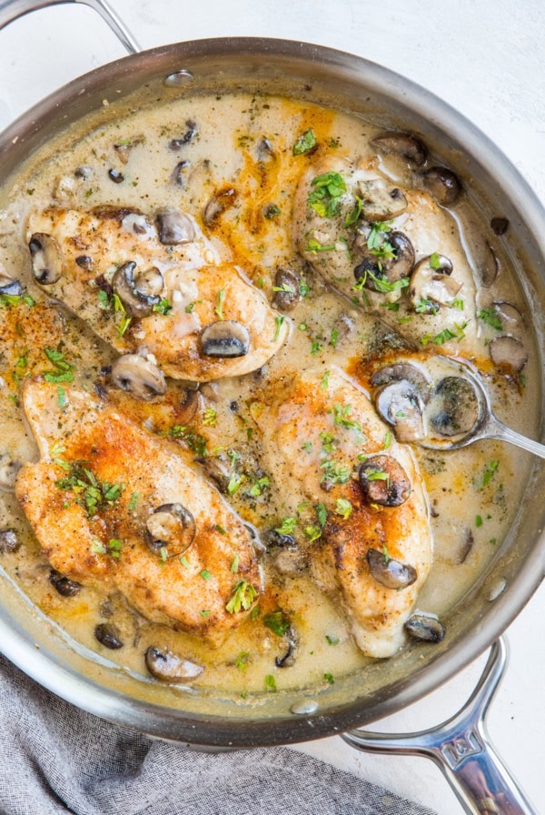 Stainless steel skillet with gluten-free dairy-free Chicken Marsala. A napkin to the side. Ready to serve.