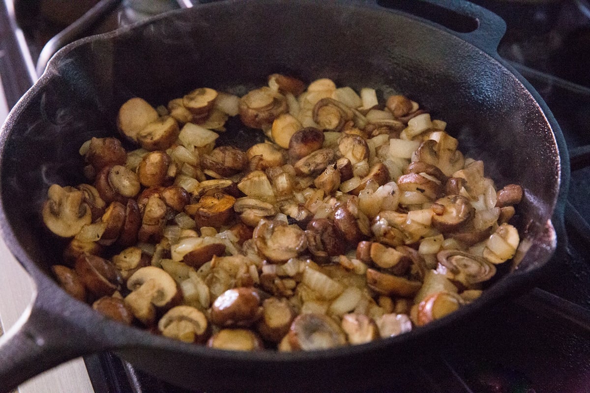 Sauteing mushrooms and garlic in a cast iron skillet.