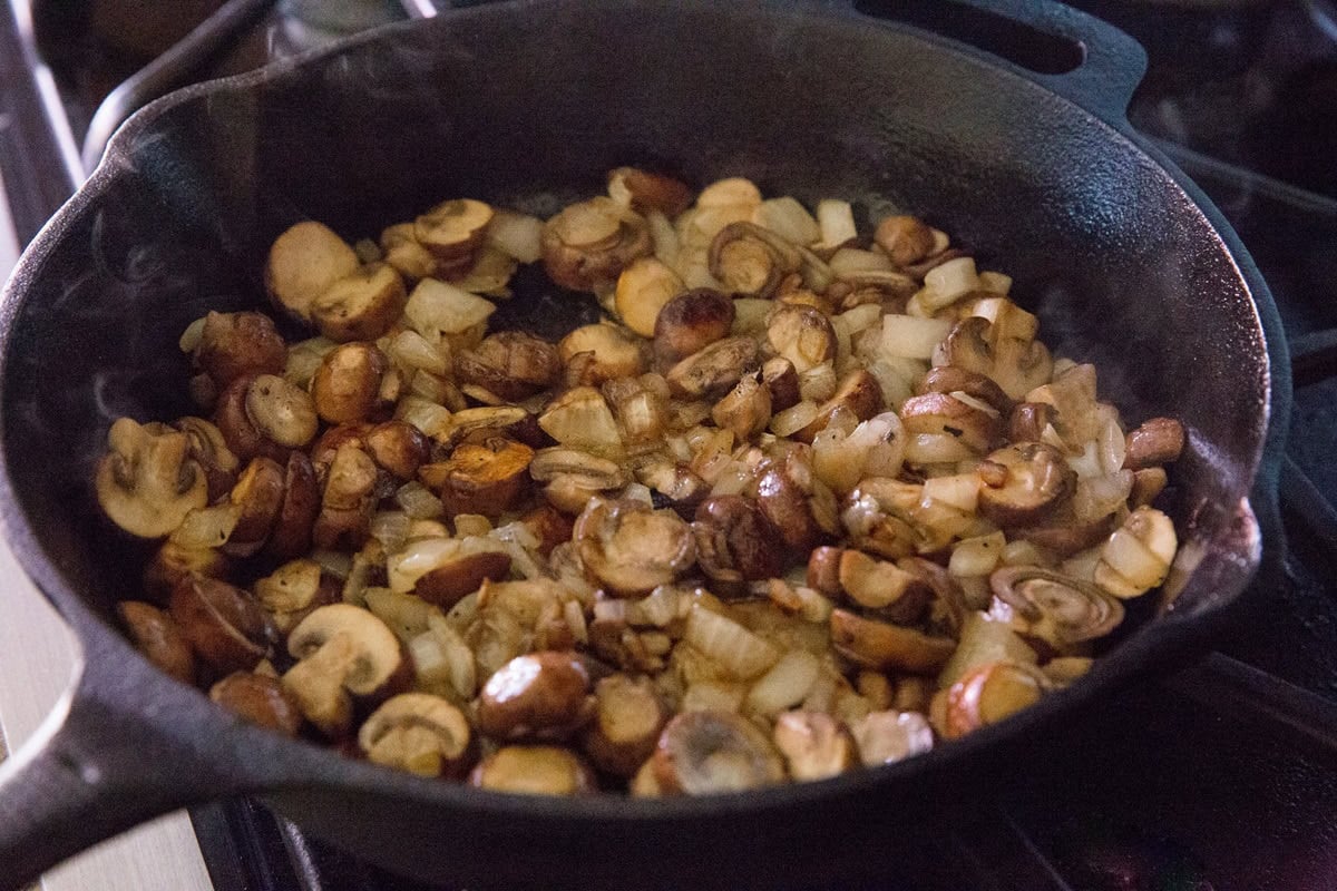 Sauteing mushrooms and garlic in a cast iron skillet.