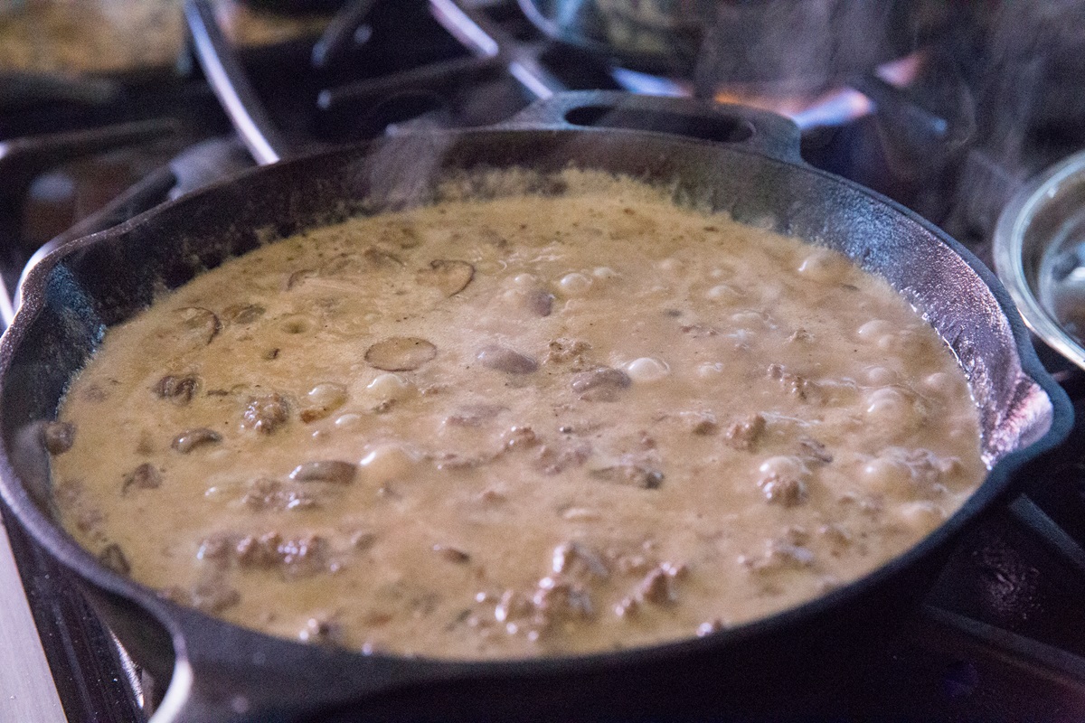 creamy mushroom sauce boiling in a cast iron skillet