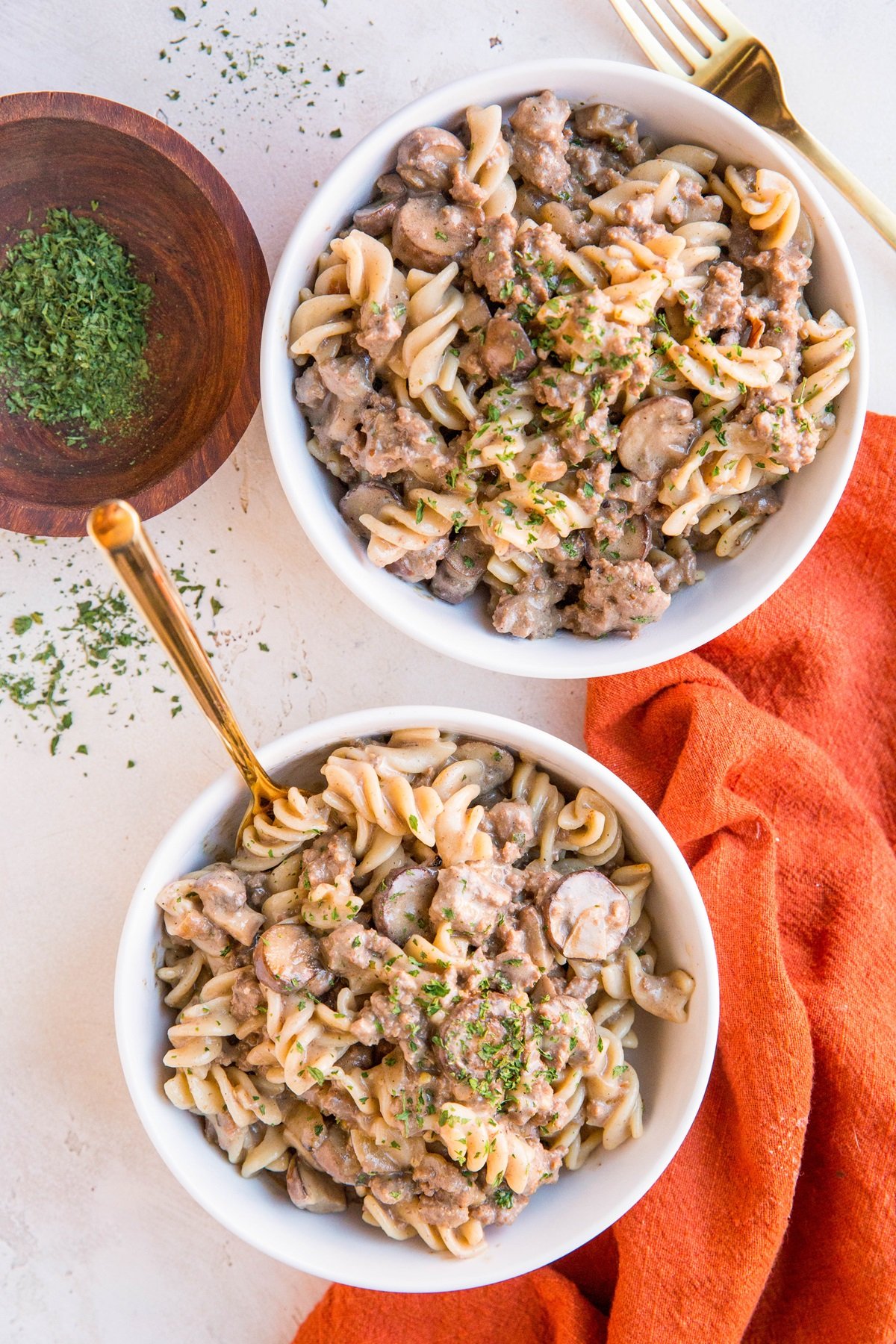 Ground Beef Stroganoff made dairy-free and gluten-free in two white bowls with a red napkin to the side.
