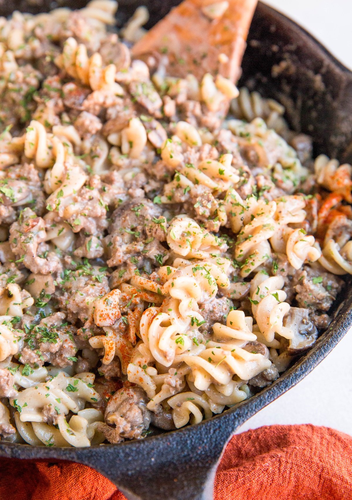 Cast iron skillet with ground beef stroganoff in it, ready to serve.