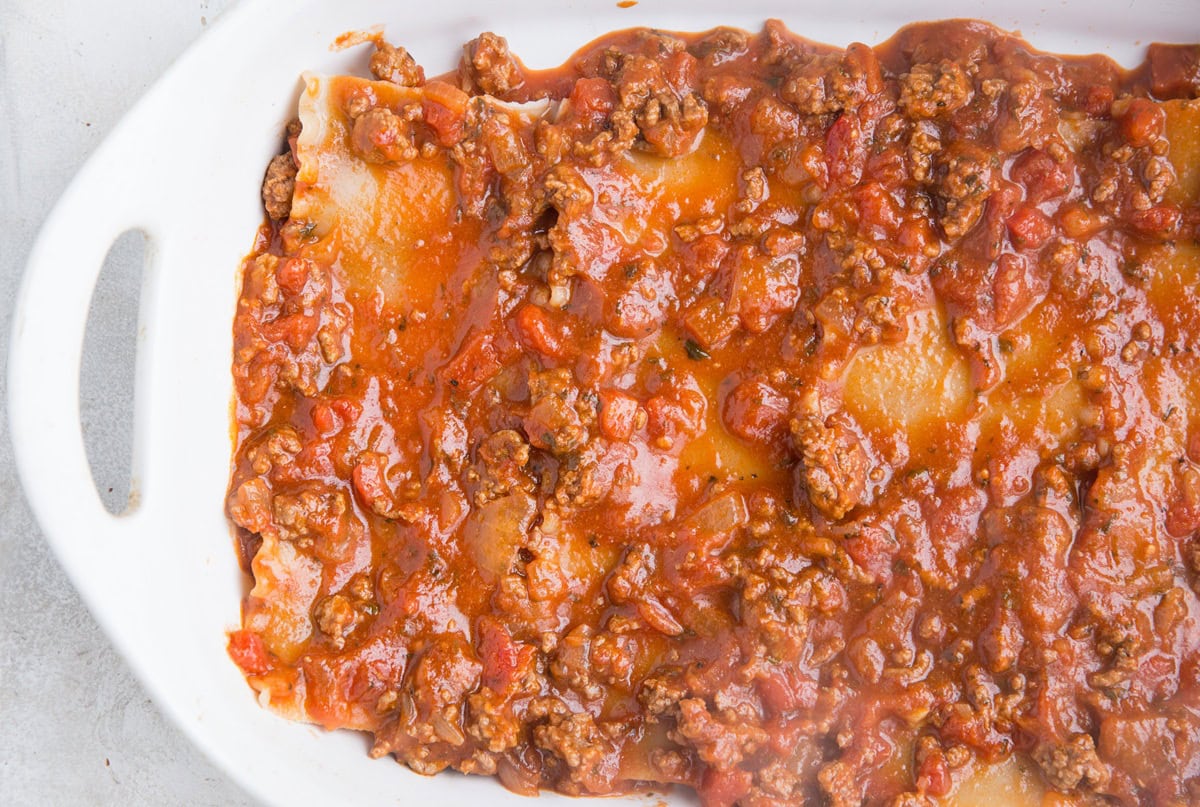 Layers of noodles and meat sauce to make layered lasagna.