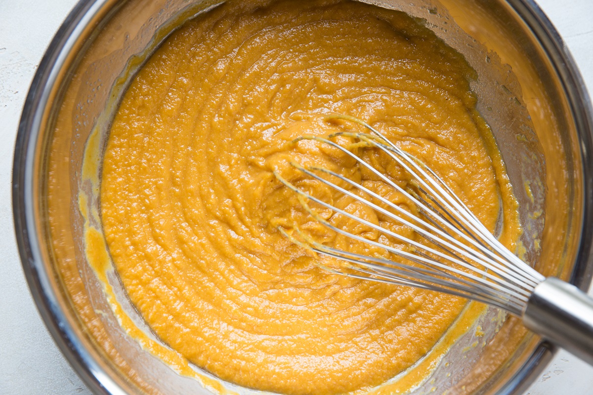 Wet ingredients for pumpkin bread mixed up in a mixing bowl.