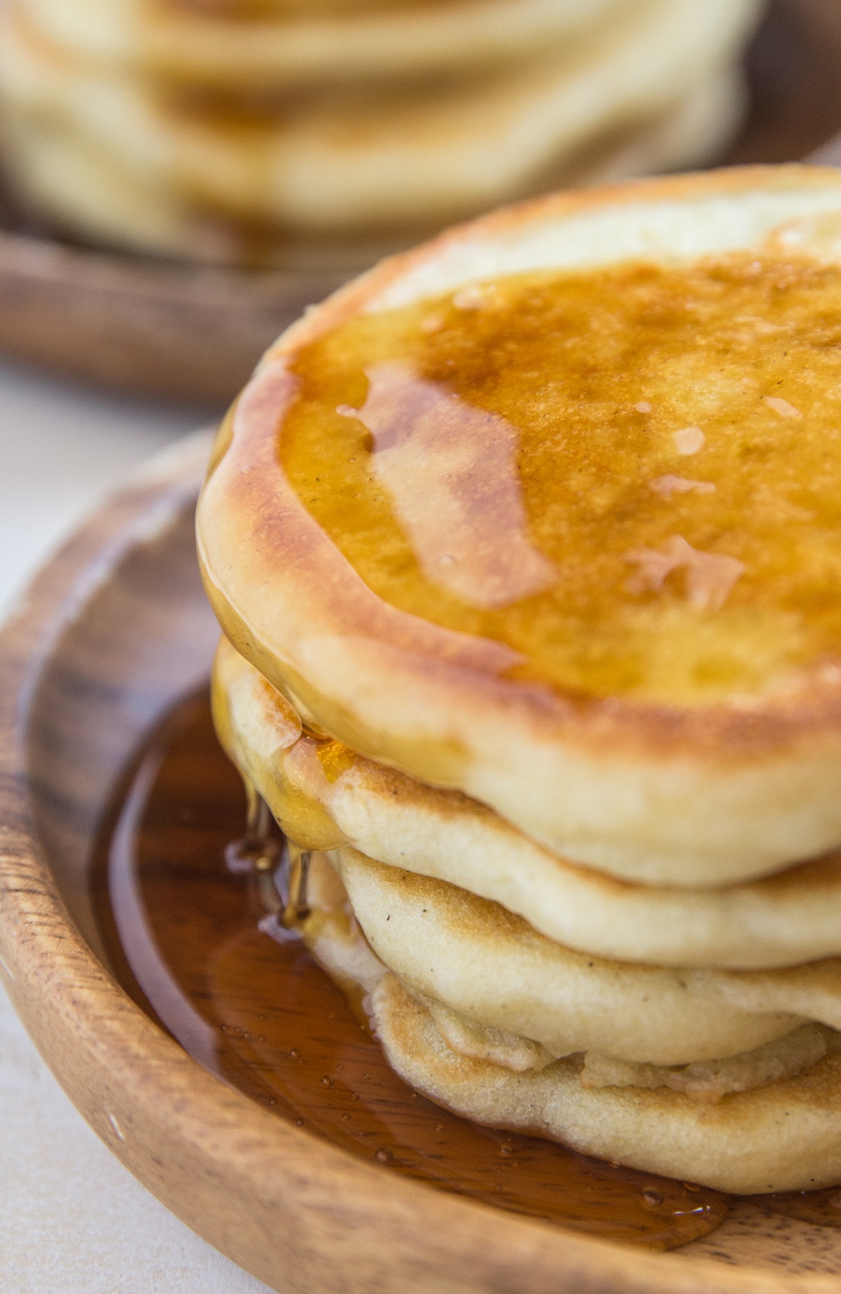 Close up shot of fluffy sourdough pancakes with syrup dripping down