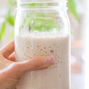 Hand holding jar of sourdough starter