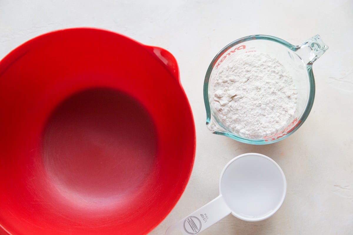mixing bowl, measuring cup with flour and measuring cup with water.