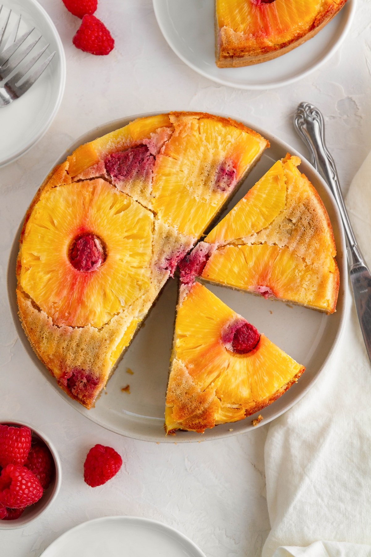 Pineapple upside down cake on a white background with slices. Ready to serve.